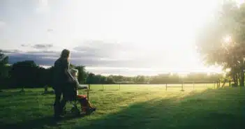 woman standing next to woman riding wheelchair